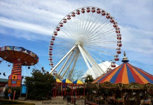 a ferris wheel and a carousel with Navy Pier in the background