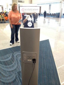 a woman standing next to a power outlet