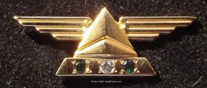 a gold triangle with three gems on it