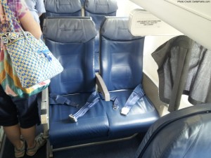 a woman standing in an airplane seat