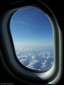 a window of an airplane with clouds