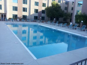 a pool with chairs in front of a building