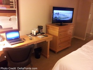 a desk with a laptop and a tv on it