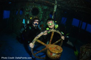 scuba divers holding a steering wheel