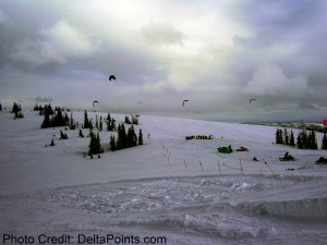 a group of people flying kites in the snow