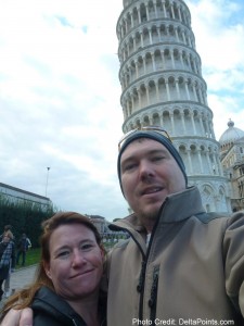 a man and woman taking a selfie in front of a leaning tower