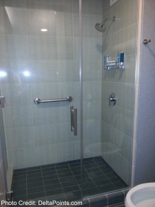 a glass shower with a metal handle