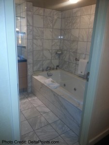 a bathroom with a bathtub and tile walls