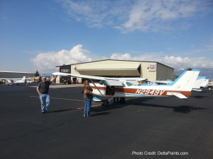 a couple of people standing next to a small plane