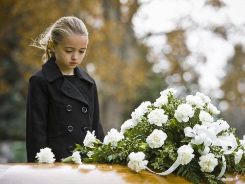 a girl standing next to a casket